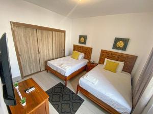 Habitación pequeña con 2 camas y TV. en Acceso a la playa 2 hab 3 camas 6 pax bella piscin, en Punta Cana 25 fotos más
