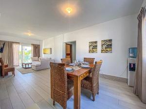 Un comedor con mesa y sillas de madera. en Acceso a la playa 2 hab 3 camas 6 pax bella piscin, en Punta Cana