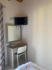 a desk with a mirror and a tv on a wall at Endless Seaview Apartment A in Alykes