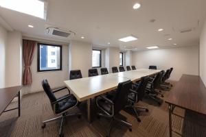 una sala de conferencias con una mesa larga y sillas en Matto Terminal Hotel, en Hakusan