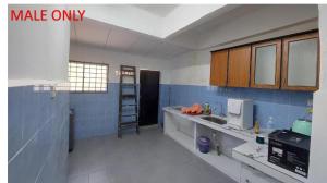 una cocina con paredes de azulejos azules y armarios de madera. en Roomstay Fiq, en Kulim
