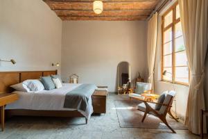 een slaapkamer met een bed, een bureau en een stoel bij Hotel Hércules in Querétaro