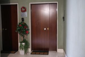 サレルノにあるLuxury B&B Charlemagneの廊下にある木製のドアとその横にある植物
