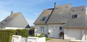 a white house with a gray roof and a white garage at Le Paradis des Fleurs in Le Tréport