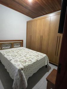 um quarto com uma cama e armários de madeira em Casa Almeida em Tiradentes