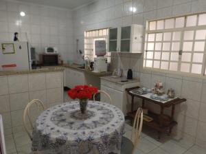 uma cozinha com uma mesa com um vaso de flores em Casa da Cidóca em Olímpia