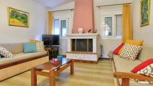 a living room with a couch and a fireplace at Villa Vivere in Corfu Town