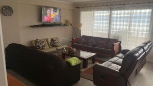 a living room with two couches and a tv at Departamento en Condominio La Puntilla Villarrica in Villarrica