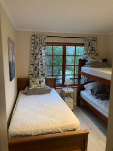 a bedroom with two bunk beds and a window at Departamento en Condominio La Puntilla Villarrica in Villarrica