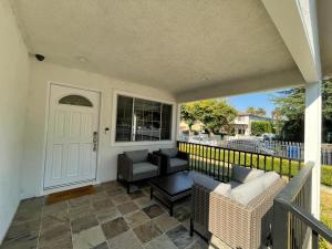 - une terrasse couverte avec 2 chaises et une porte blanche dans l'établissement Charming Bright Traditional Home in Sherman Oaks, à Sherman Oaks
