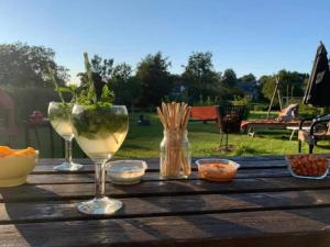 un tavolo in legno con bicchieri da vino e ciotole sopra di Holiday home for 8 people in the Belgian Ardennes a Bullange/Büllingen