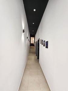 - un couloir dans un bâtiment doté de murs blancs et de carrelage dans l'établissement Appartement Idéal : Proximité, Confort et Élégance, à Tetouan
