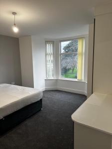 a bedroom with a bed and a large window at OYO Cheetham Hill Guest House in Manchester