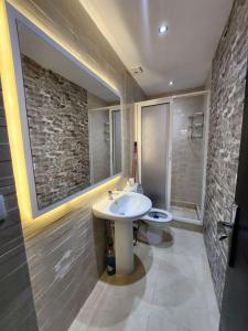 a bathroom with a white sink and a stone wall at Appartement Idéal : Proximité, Confort et Élégance in Tetouan