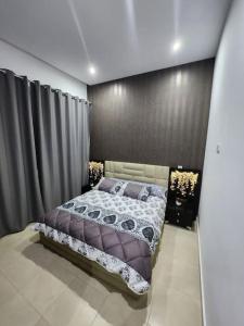 a bedroom with a bed and a black wall at Appartement Idéal : Proximité, Confort et Élégance in Tétouan