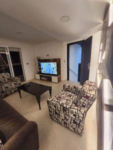 a living room with couches and a flat screen tv at Appartement Idéal : Proximité, Confort et Élégance in Tétouan