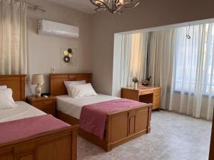 a bedroom with two beds and a window at Bright and spacious 2bdr apt للعائلات Nasr city heart in Cairo