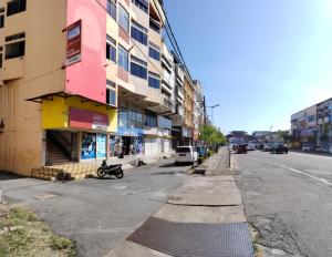 una calle con un edificio al lado de la carretera en Hotel Kenangan en Kota Bharu
