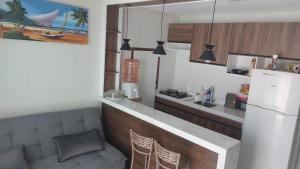 a kitchen with a counter and a white refrigerator at Rsolmar2023 apartamentos in Tamandaré