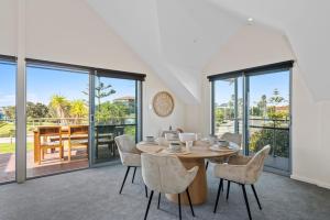 a dining room with a table and chairs and sliding glass doors at Beachside Bliss 2 Bedroom Family Villa in Mandurah