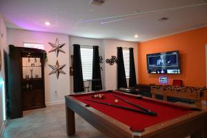 a living room with a pool table and a tv at Luxurious 8-Room Oasis near Disney in Kissimmee