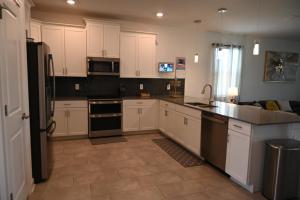 a kitchen with white cabinets and black appliances at Luxurious 8-Room Oasis near Disney in Kissimmee