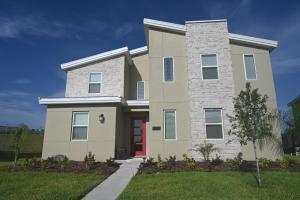 a house with a red door in a yard at Luxurious 8-Room Oasis near Disney in Kissimmee