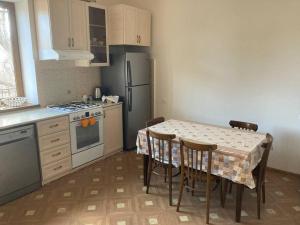 a kitchen with a table with chairs and a refrigerator at Собственный дом в фруктовом саду 