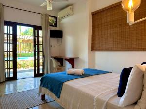 1 dormitorio con 1 cama, TV y mesa en Pousada Sambaki, en Paraty