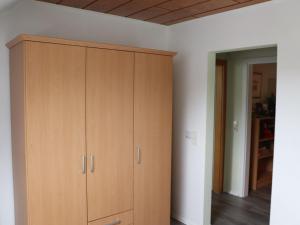 a large wooden cabinet in a room with white walls at Fewo-rosenberger-sauerland in Lennestadt