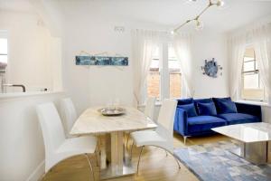uma sala de estar com uma mesa e um sofá azul em Sydney CBD Waterview Apartment 54A em Sydney