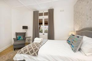 um quarto com uma cama, uma cadeira e uma janela em Sydney CBD Waterview Apartment 54A em Sydney