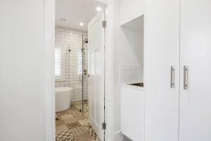 uma casa de banho branca com um chuveiro e um lavatório. em Sydney CBD Waterview Apartment 54A em Sydney
