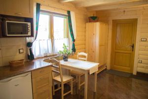 a kitchen with a table and chairs in a room at Domek góralski u Felusia in Szczawnica +3 photos