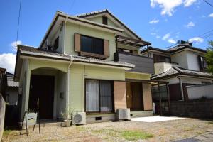 una casa con una puerta delantera y una ventana en にし阿波ねすと, en Higashimiyoshi