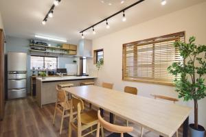 cocina y comedor con mesa de madera y sillas en にし阿波ねすと, en Higashimiyoshi