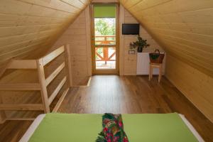 a attic room with a bed and a tv at Domek góralski u Felusia in Szczawnica