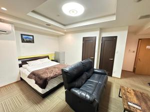 a bedroom with a bed and a leather couch at City Villa Rアネックス in Osaka