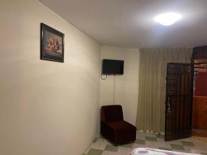 伊卡的住宿－Entre Cava y Cata，一间房间,墙上有椅子和电视