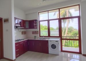 a kitchen with a sink and a washing machine at Shine Ray VILLA in Galle