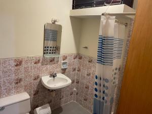a bathroom with a sink and a shower curtain at Entre Cava y Cata in Ica