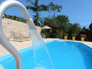 un tobogán de agua en una piscina en POUSADA DAS ORQUIDEAS20 en Guapimirim