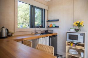 uma cozinha com um lavatório e um micro-ondas em The Cottage - Springvale em Alexandra