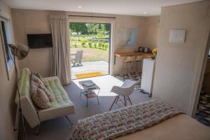 1 dormitorio con cama, sofá y cocina en The Cottage - Springvale en Alexandra