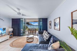 una sala de estar con un sofá y una mesa en By The Sea Shore With Pool, en Airlie Beach
