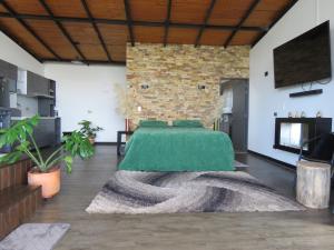 Una habitación con una cama con una manta verde. en San Simon Glamping,El peñol,Guatape, en Guatapé