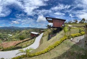 a house on top of a hill with a road at San Simon Glamping,El peñol,Guatape in Guatapé