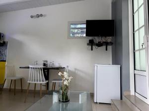- un salon avec un réfrigérateur blanc et une table dans l'établissement On ti kanpo, à Bosrédon