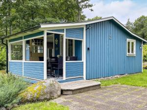 a blue shed with a porch and a patio at Holiday home KARLSHAMN III in Karlshamn