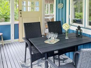 a black table and chairs on a porch at Holiday home KARLSHAMN III in Karlshamn